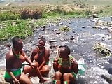 Busty topless African girls singing in river